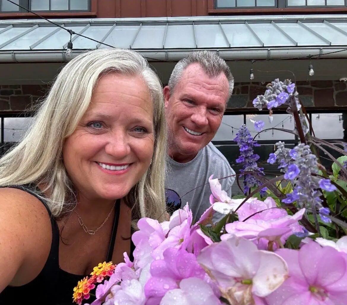 Smiling couple with pink and purple flowers