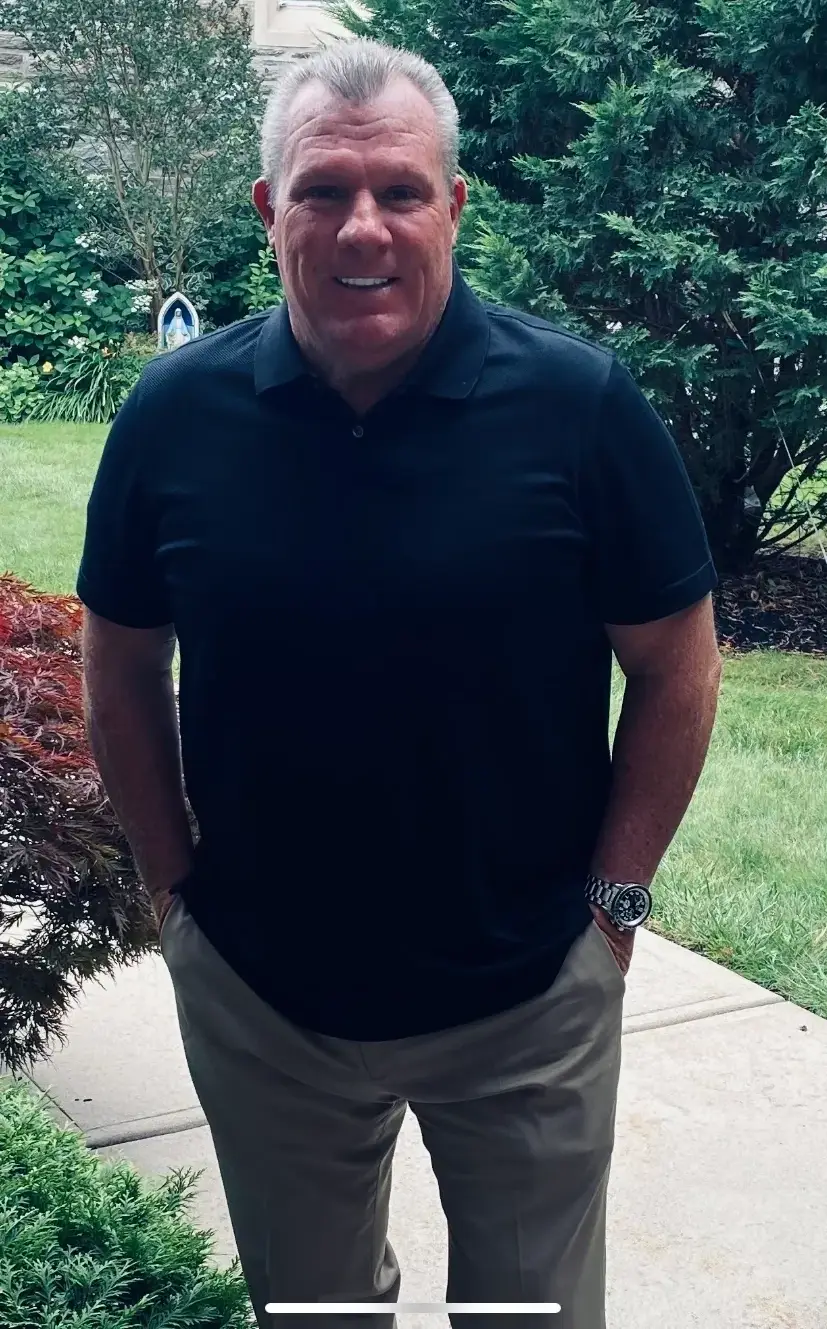 Smiling man in black polo shirt outdoors
