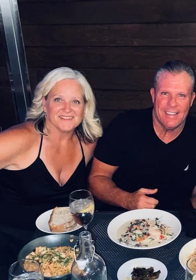 Smiling couple enjoying dinner with wine