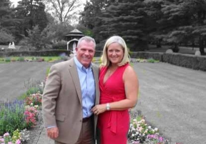 Couple smiling in formal wear in garden