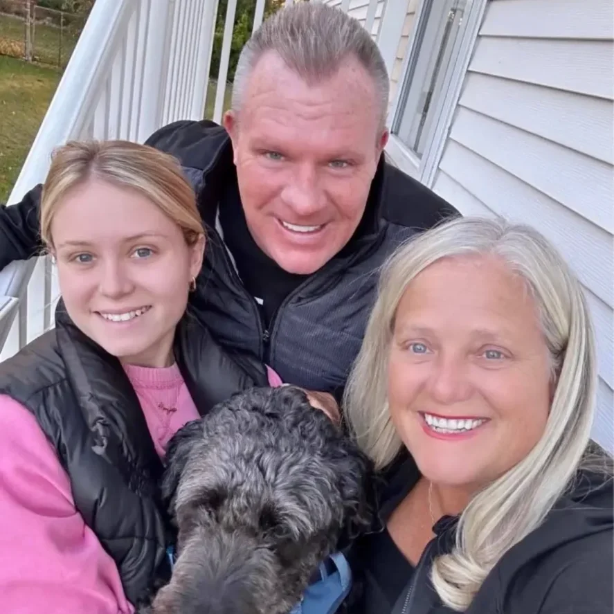 Smiling trio taking selfie with black dog