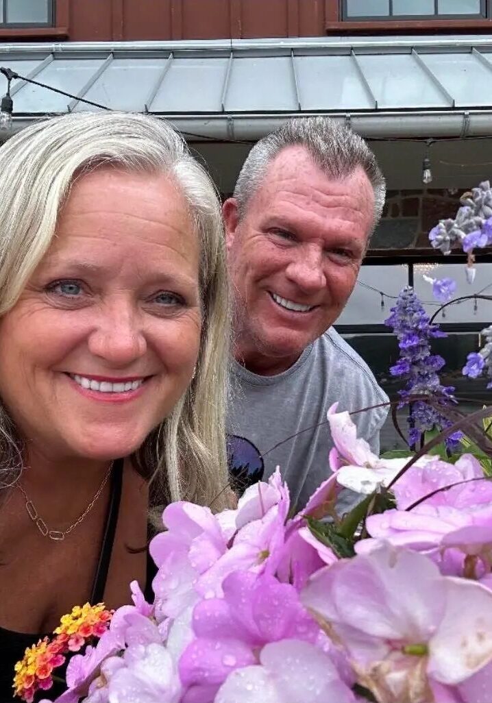 Smiling couple with pink and purple flowers