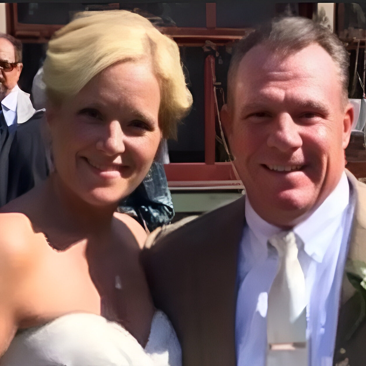 Smiling bride and groom in sunny courtyard